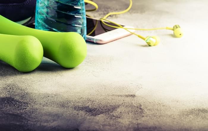 Female fitness concept: light green dumbbells, isotonic blue wat