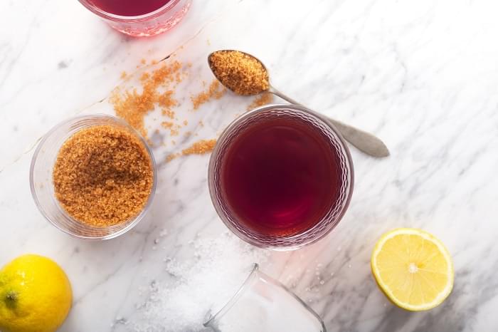 Homemade Isotonic Energy Drink and Ingredients. Glass With Red Liquid, top view